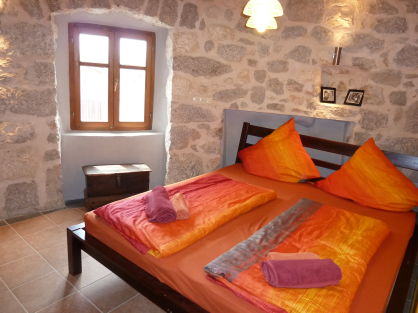 Schlafzimmer mit Steinmauer und Nische fÃ¼r das Bett