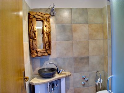 Bad mit Steinwaschbecken und Holzspiegel